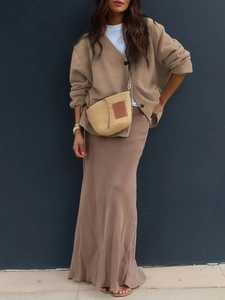 Chic women casual outfit featuring brown knitted cardigan and long skirt with straw bag
