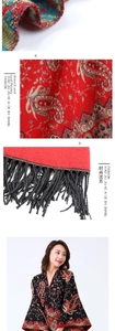 Macro detail of red and black paisley pattern scarf with elegant long black tassels