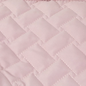 Detailed close-up of pink quilted fabric texture showing professional stitching patterns
