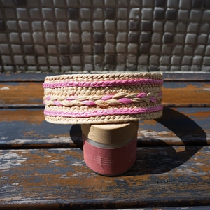 Detailed view of woven raffia headband with pink diamond pattern and natural texture