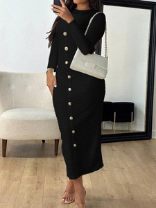 Detail showing the elegant black knit dress with a front row of decorative golden buttons