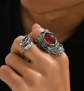 Close-up of vintage silver dragon ring set with large red gemstone on a male hand
