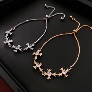 Adjustable cross flower charm bracelet with zircons in gold and silver finish