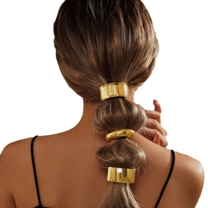 Set of three golden metal hair rings and clips for ponytails on a female model