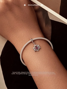 Silver woven mesh bracelet featuring a crown heart charm with red and pink gemstones