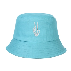 Dettaglio del ricamo bianco con mano di teschio su un cappello a secchiello blu