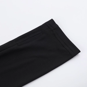 Close-up of black long sleeve top cuff featuring a functional thumbhole and fine stitching