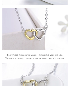 Close-up of interlocking silver and gold heart pendant necklace with romantic text engraving