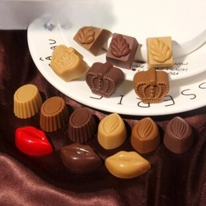 Detailed macro view of realistic resin chocolate charms on a white porcelain plate