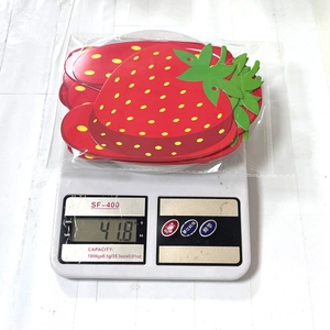 Close-up of strawberry-shaped party paper plates being weighed on a digital scale for accuracy