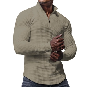 Detailed view of khaki waffle knit fabric and half-zip stand collar on men's pullover