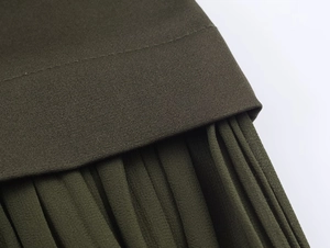 Close-up of military green pleated midi dress with detailed waist stitching and fabric texture