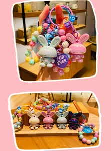 Close-up of cute electroplated rabbit keychains with colorful beads and letter charms