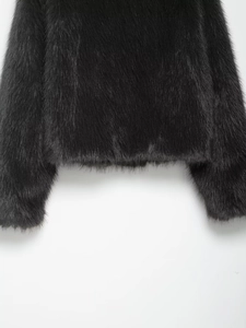 Detailed close-up of the plush faux fur hem and cuffs on a black stand-collar jacket