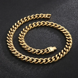 Collier à maillons cubains dorés en acier inoxydable sur un fond noir texturé élégant