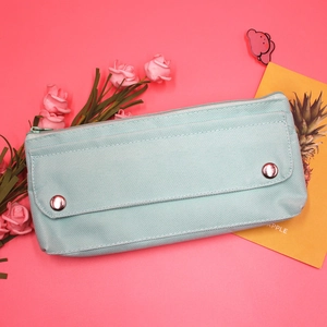 Detail of mint green oxford fabric pencil case with silver metal snap buttons