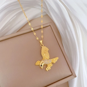 Luxurious gold eagle pendant necklace with sparkling crystals on silk background