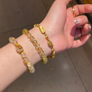 Close-up of layered yellow citrine crystal bracelet with zircon flower and gold beads