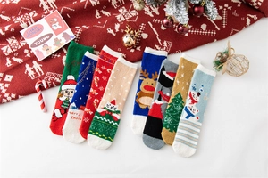 Flat lay of 8 pairs of Christmas coral fleece socks with reindeer and Santa patterns