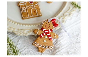 Detailed close-up of a resin gingerbread man ornament with red scarf and white ribbon