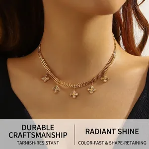 Detail of gold snake chain necklace featuring five sparkling zircon clover pendants