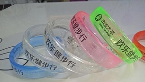 Close-up of colorful LED glowing silicone bracelets with printed logos for events