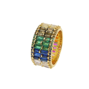 Detailed shot of gold wide band ring with pave set multi-colored rectangular gemstones