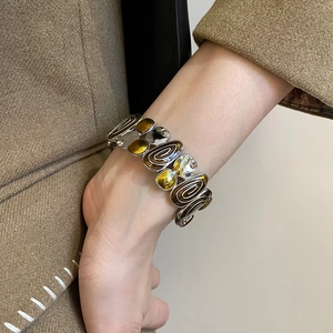 Detail of vintage silver cuff bracelet with amber resin and spiral metal texture