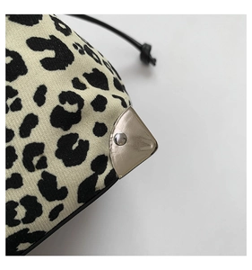 Detail of leopard print knit bucket bag with silver metal corner protectors and texture