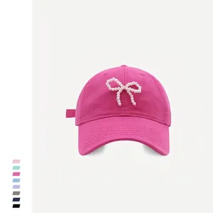 Detail of pink cotton baseball cap with pearl bow embroidery and adjustable strap