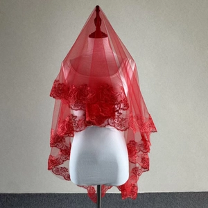 Detailed close-up of red wedding veil with elegant lace floral embroidery along the edges