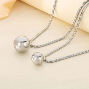 Detail view of silver stainless steel sphere pendant with sleek square snake chain