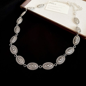 Close-up of vintage silver oval metal chain link with embossed texture for waist belt