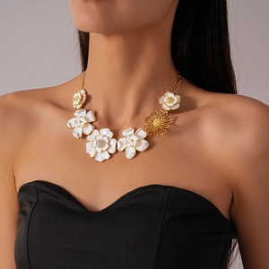 Detail of white enamel flower necklace with gold trim and hollow floral design accents