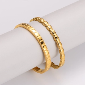 Set of two gold stainless steel bangles featuring square and ribbed textured patterns