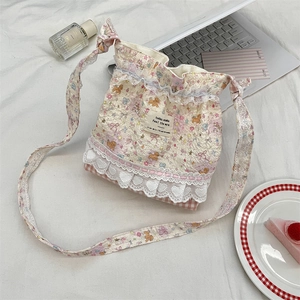 Detail of floral crossbody bag with cute bear patterns and delicate lace decorations