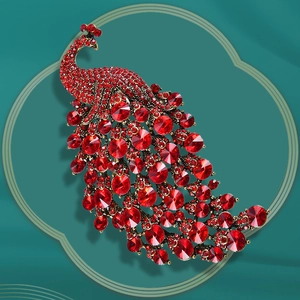 Macro detail of vintage red crystal peacock brooch featuring intricate metal craftsmanship