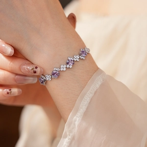 Detailed view of silver zircon bracelet with purple gemstones on female wrist