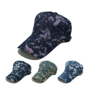 Detail of gradient denim baseball caps with gold embroidered stars and moon patterns