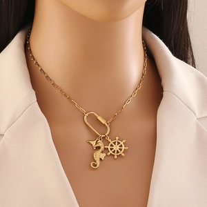 Gold seahorse and rudder charm necklace on model featuring carabiner link design