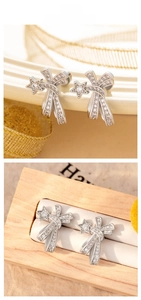 Détails de boucles d'oreilles en zircon étoile et ruban sur un présentoir en bois chic