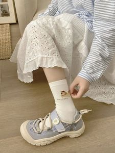 Detail of white mid-calf sock with cute dog embroidery and dog cake text pattern