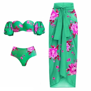 Detailed flat lay of three-piece green floral bikini set with matching sarong wrap