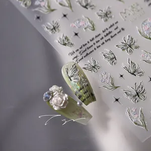 Macro view of 3D silver butterfly and lily of the valley relief nail art stickers