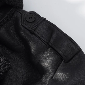Close-up of black faux leather jacket shoulder featuring epaulet detail and plush lining