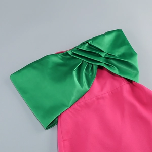 Detail of a large satin bow on a contrast color hot pink and green evening gown