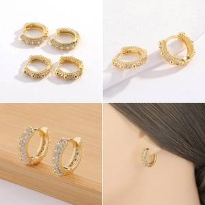 Detalle de aros bañados en oro de 18K con micropavé de circón blanco y diseño tachuela