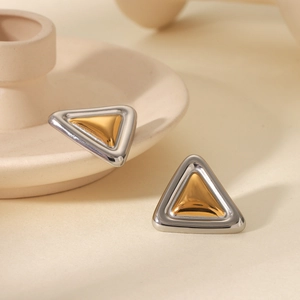 Macro shot of minimalist two-tone triangle stud earrings in gold and silver finish