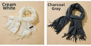 Detail of cream and heather grey cashmere scarves with elegant fringe and woven labels