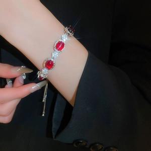 Detail of silver flower bracelet with red zircons and adjustable pull chain design